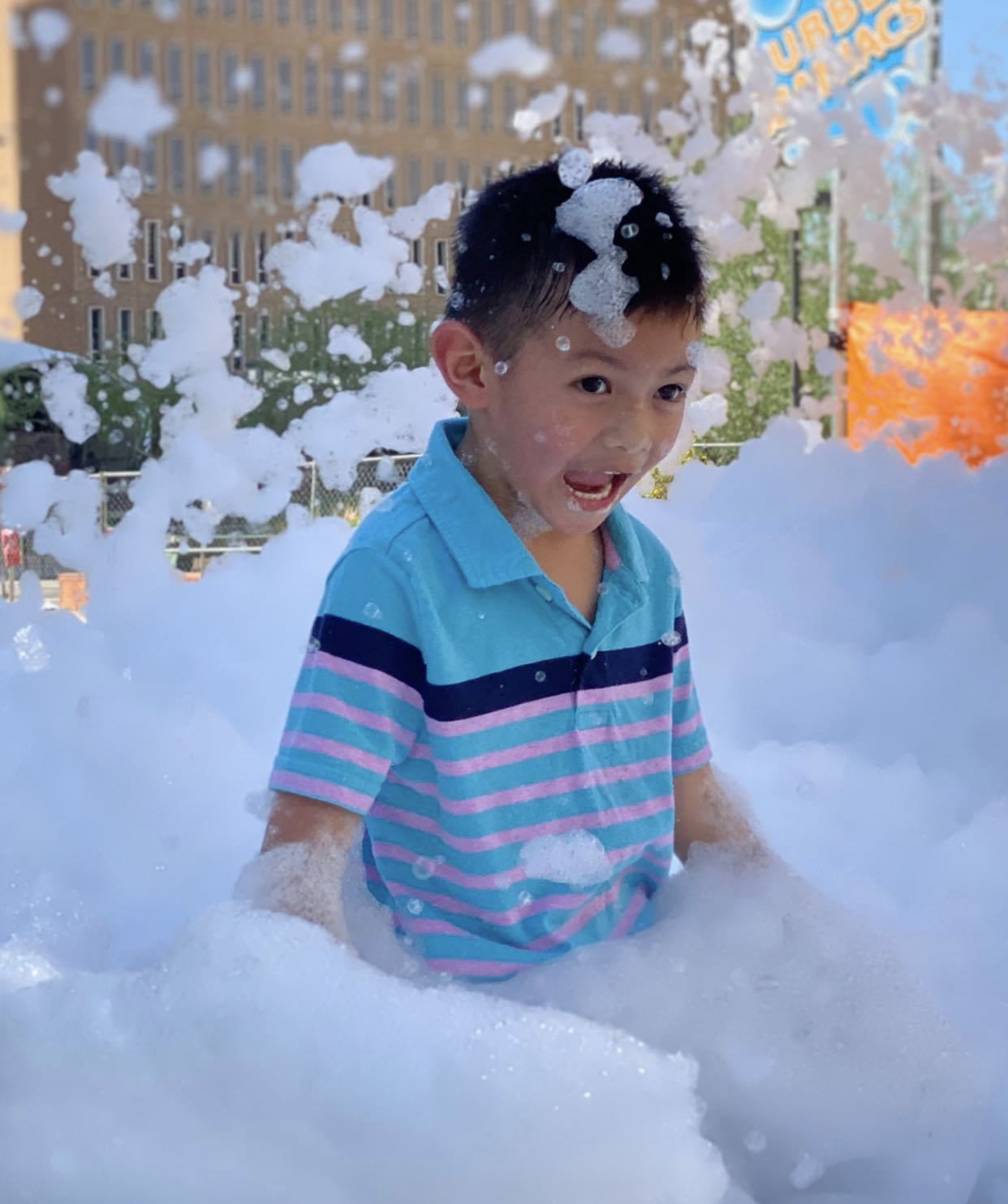 A smiling child playing in deep foam